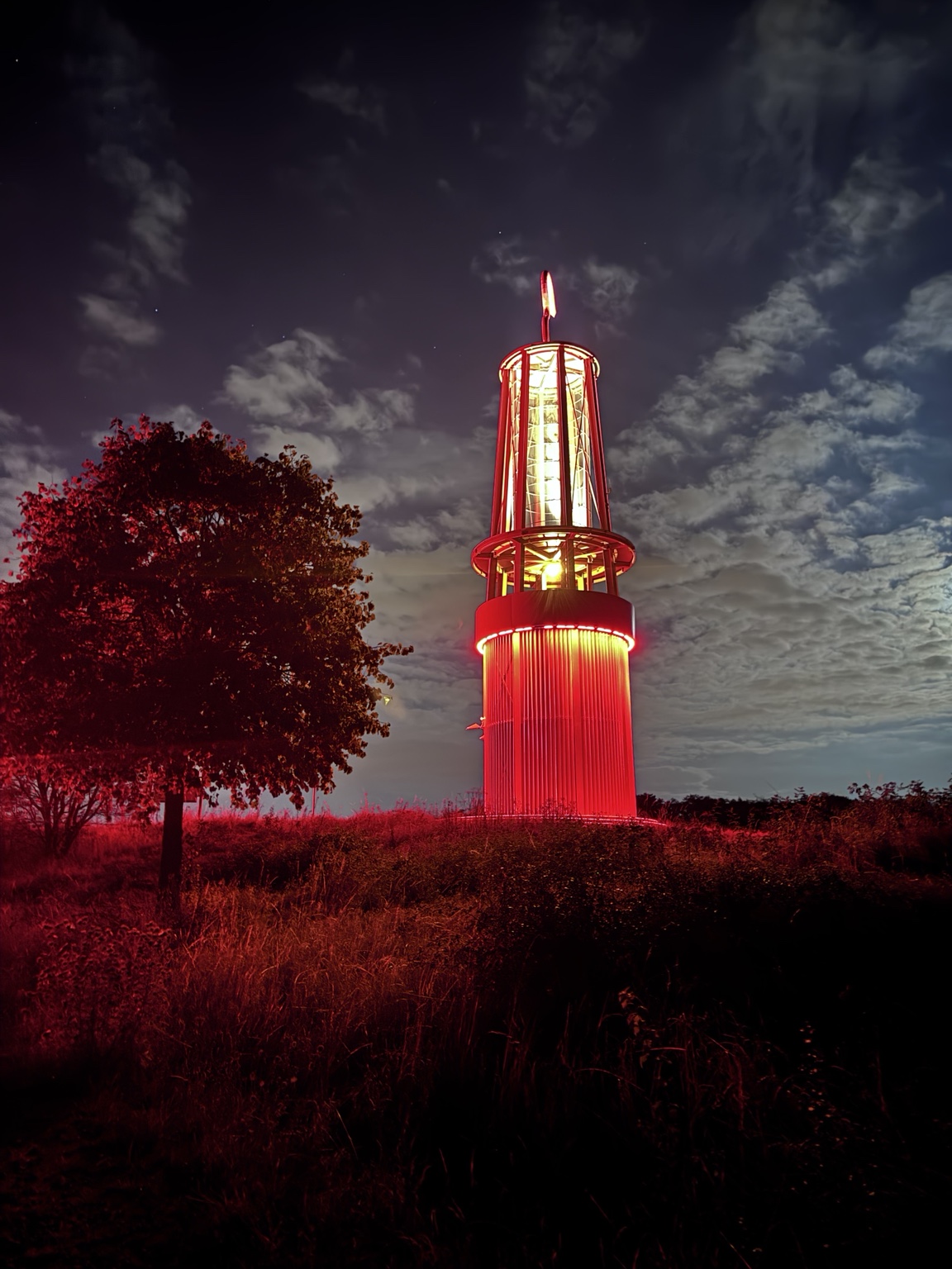 Das rot beleuchtete Geleucht auf der Halde Rheinpreußen in Moers bei Nacht
